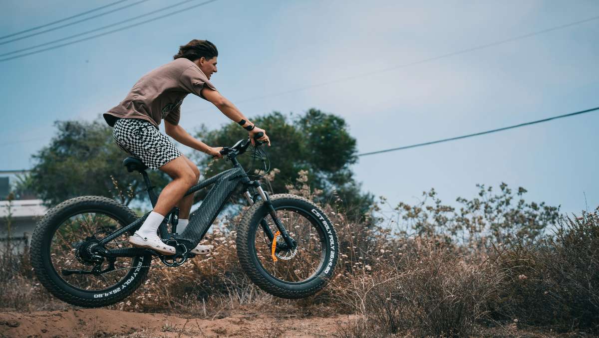 A man riding an e-mountain bike on a dirt road.