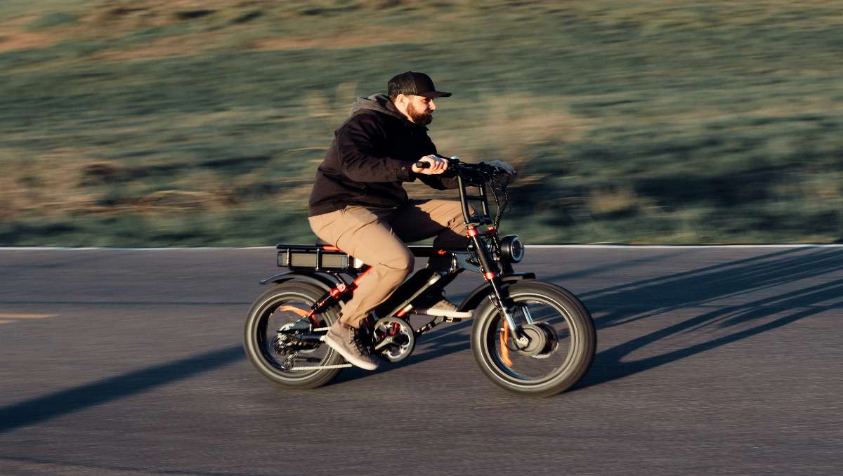 Heavy male riding ebike during golden hour sunset in the mountains