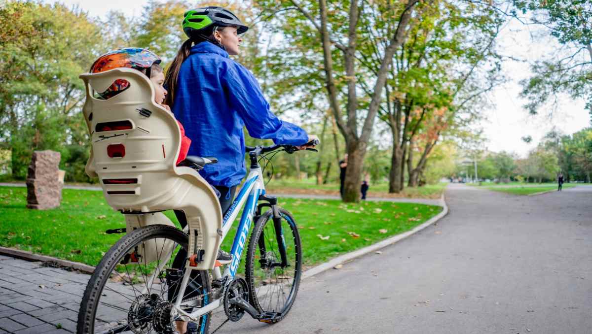 Mother with a baby sitting in baby seat in e-bike