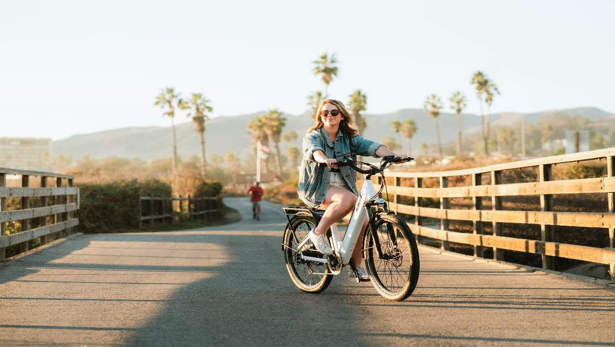 Girl riding electric hybrid bike under the sun